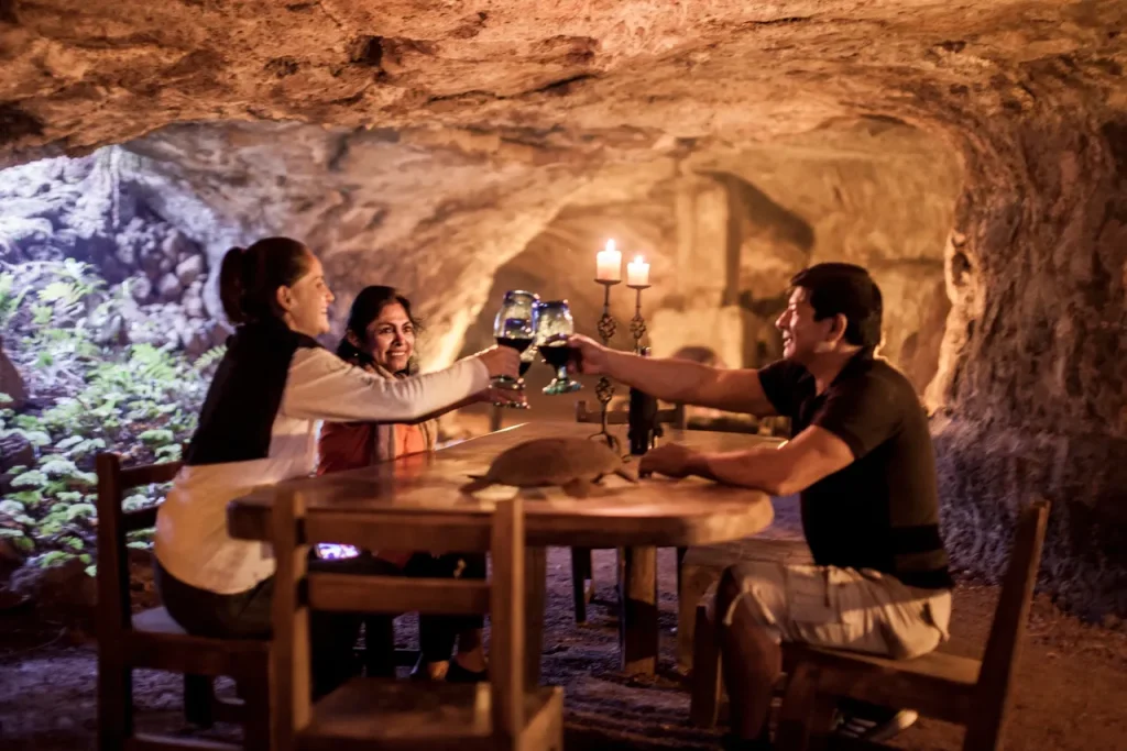A group enjoying dinner by candlelight in Lava Tunnels on The Galapagos Islands